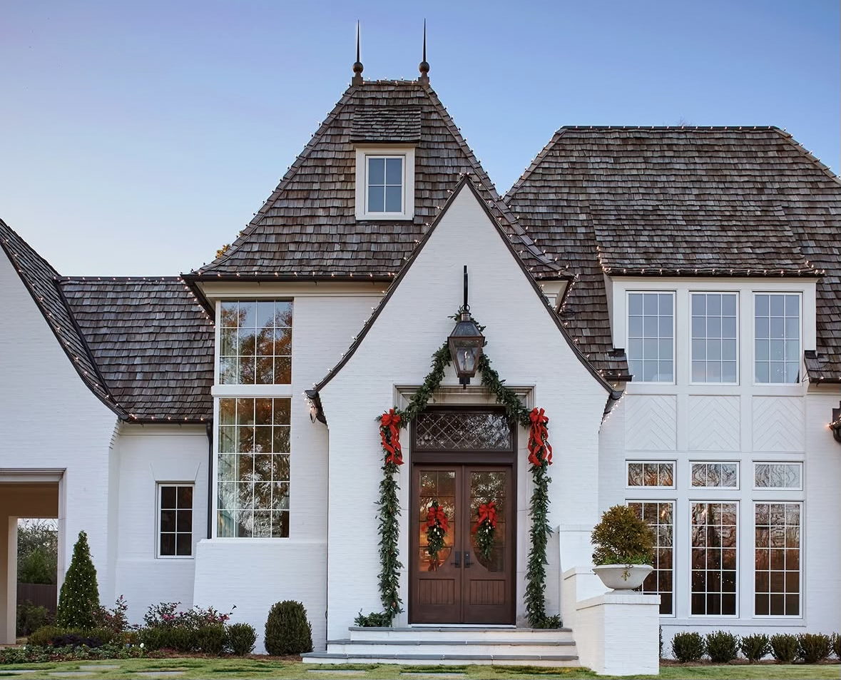 Weathered cedar shake roof on a white brick home elegantly decorated for the holidays.