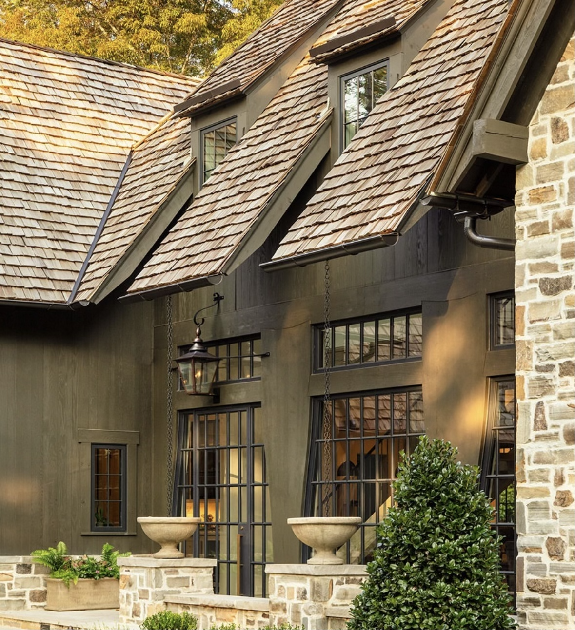 Aged cedar shake roof on a rustic-modern home with dark siding and large windows.