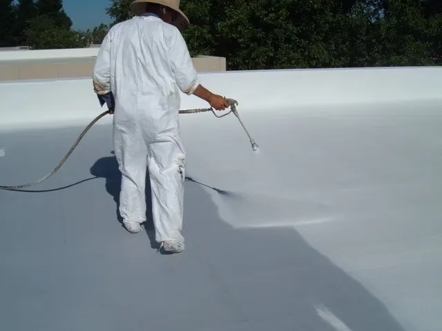 A Summit Roofing professional expertly applying a white waterproof membrane to a commercial roof.