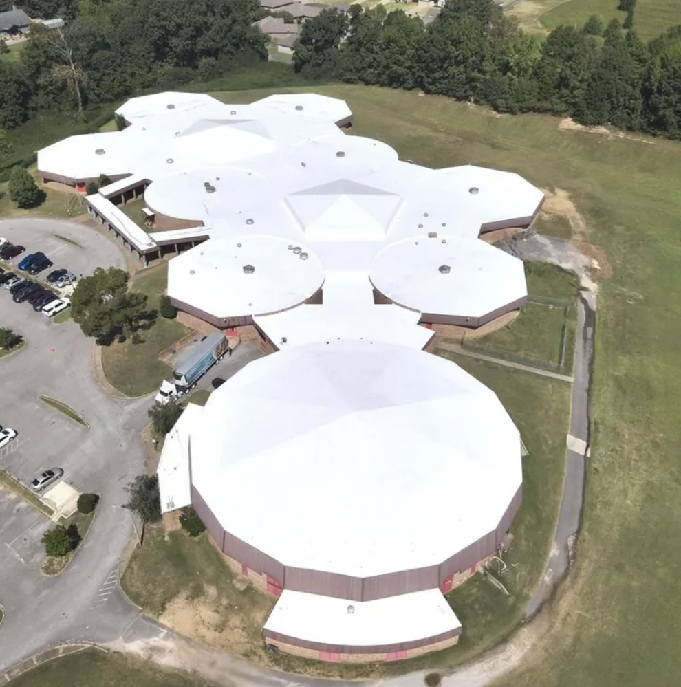 Complete fluid-applied roof restoration on a large, uniquely shaped school building, providing a seamless, energy-efficient white roof.