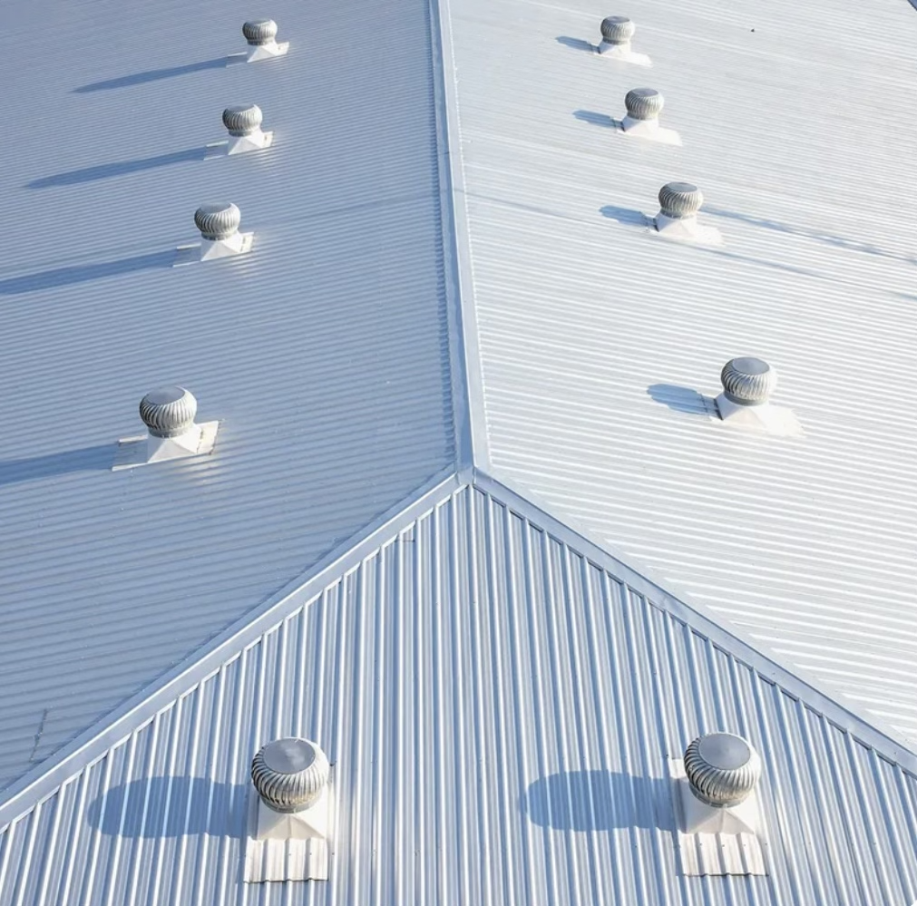 A reflective silver coating applied to a commercial metal roof, extending its life and improving energy efficiency.
