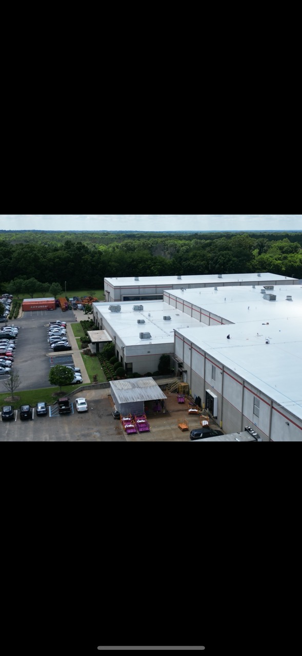 Aerial view of completed white TPO roof on a large commercial facility