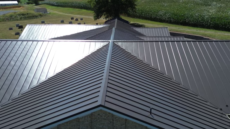 Aerial view of a dark standing seam metal roof with intricate hips and valleys.