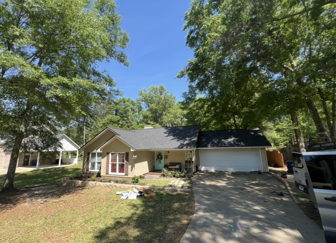 A complete roof replacement for a lovely suburban home, surrounded by mature trees.