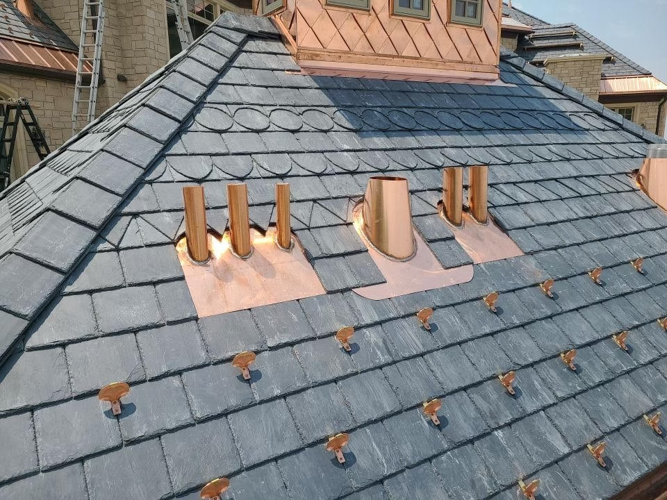 Expertly installed slate roof featuring copper flashing and snow guards for superior protection.