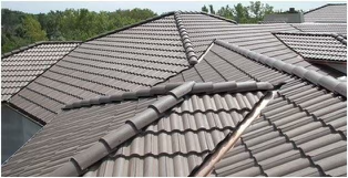 Expert installation of concrete tiles on a complex roof with multiple valleys and ridges.